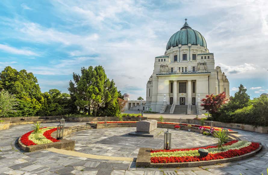 Iglesia de estilo neoclásico y atrio con flores en el cementerio central de Viena
