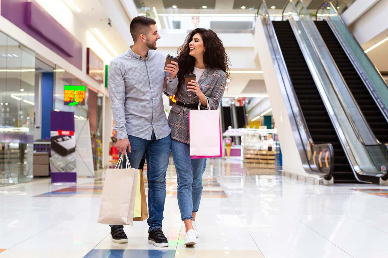 Una pareja con bolsas de compras en un centro comercial