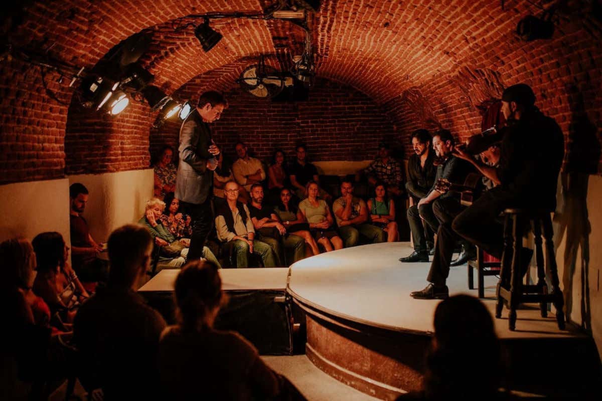 Plusieurs musiciens et un danseur de flamenco transmettant leur art dans la cave souterraine du tablao Essential Flamenco