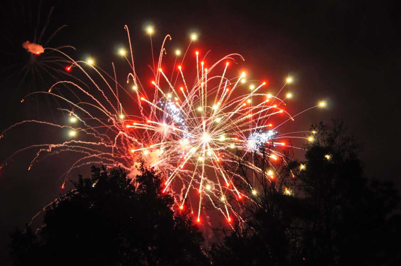 Fuegos artificiales de color rojo y blanco por la noche