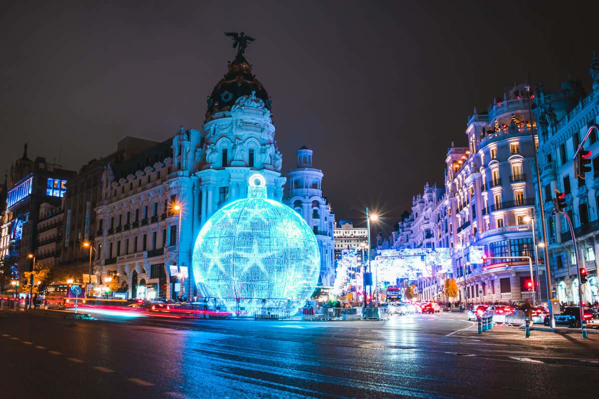 Una gigantesca bola de Navidad iluminada frente al edificio Metrópolis de la Gran Vía de Madrid