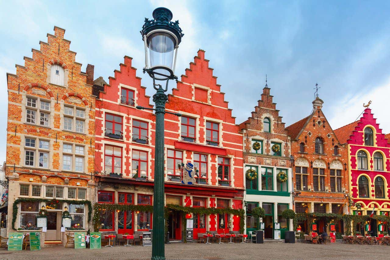Views of brightly coloured buildings and facades in Bruges Belgium with Christmas decorations outside