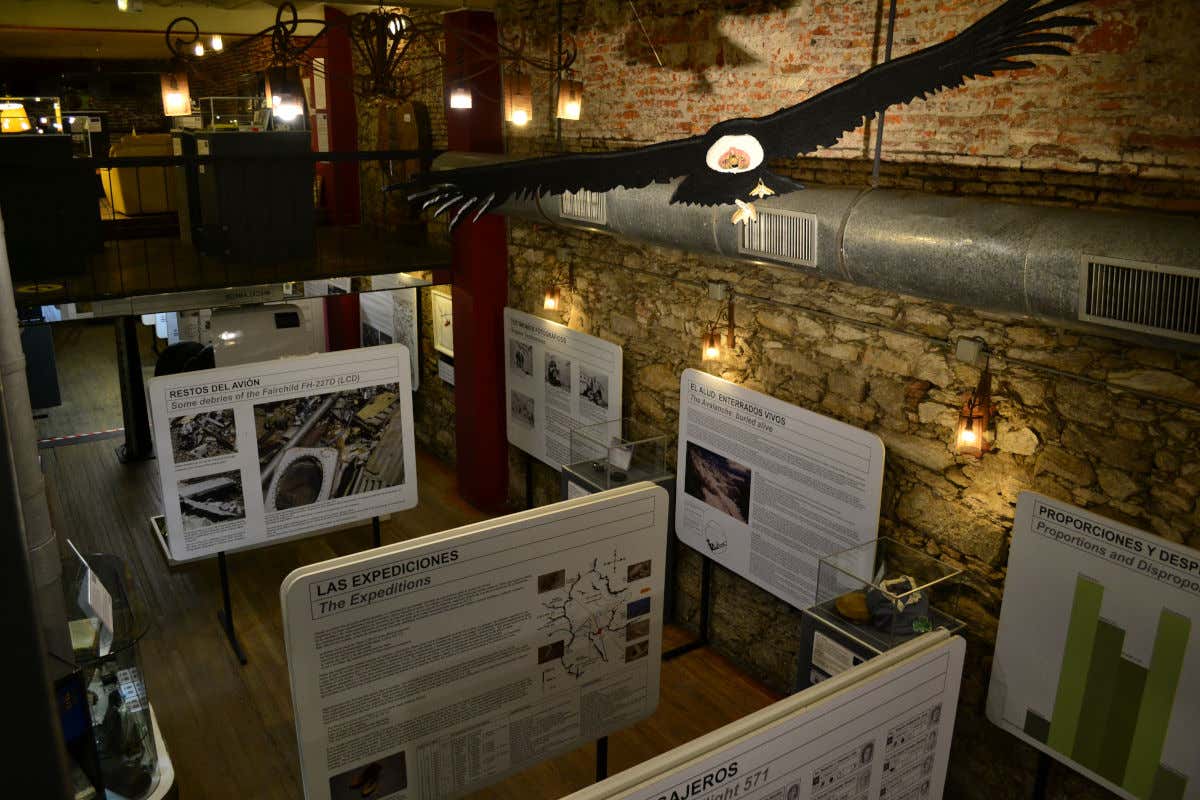 Information boards in a dimly lit room with stone walls in the Andes Museum 1972 in Montevideo