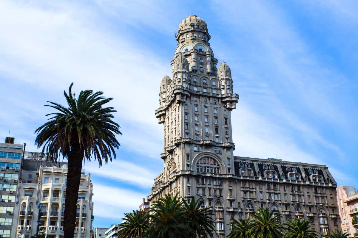 Salvo Palace in Montevideo by some palm trees under a clear sky