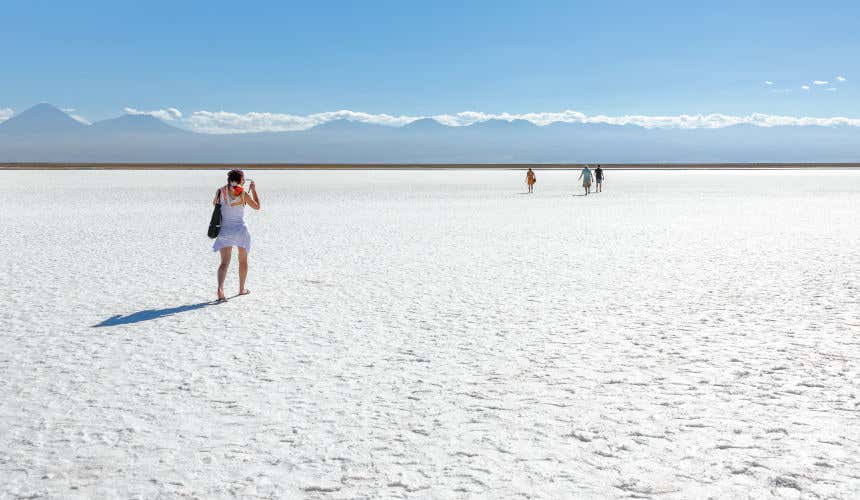 Four tourists in the extensive white Atacama Salt Flat (Salar de Atacama)