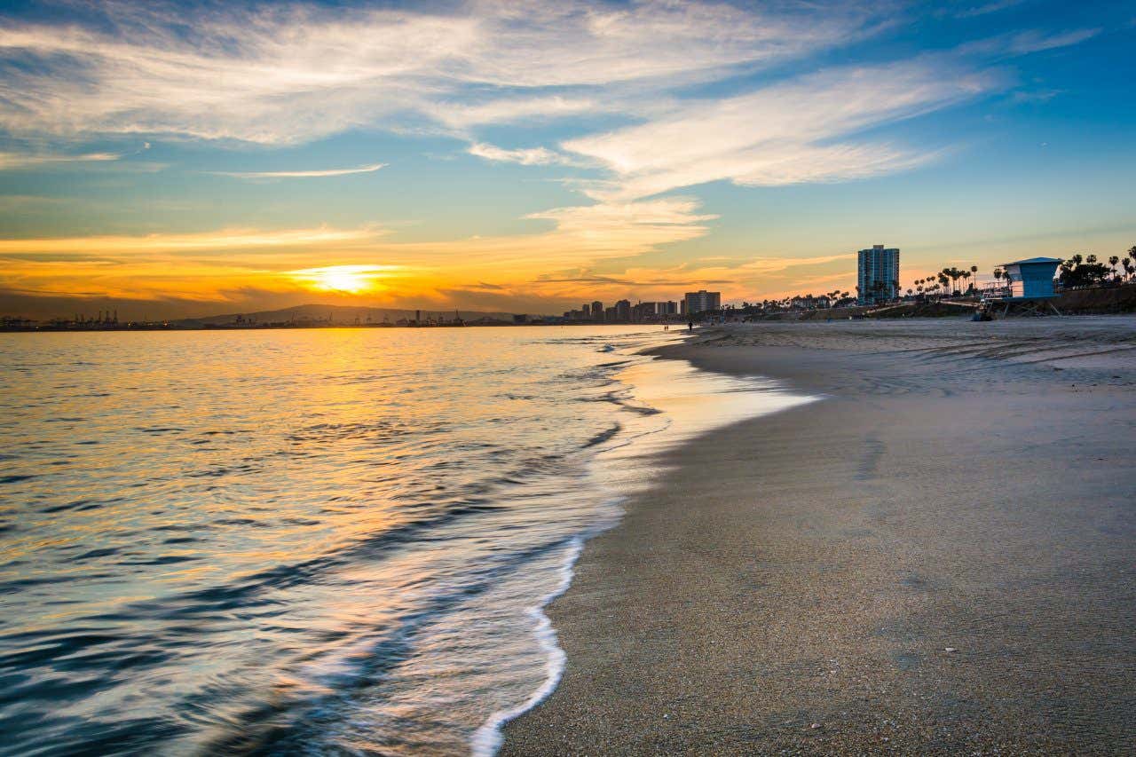 Sunset on Long Beach with mountains on teh horizon and buildings in the background
