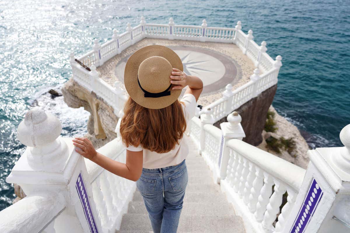 Una mujer de pelo largo de espaldas bajando por unos escalones que dan el mirador del Balcón del Mediterráneo, en Benidorm