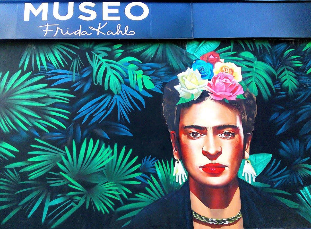 Entrance to the Frida Kahlo Museum with a mural of her face with flowers and green plants in Playa del Carmen, Mexico