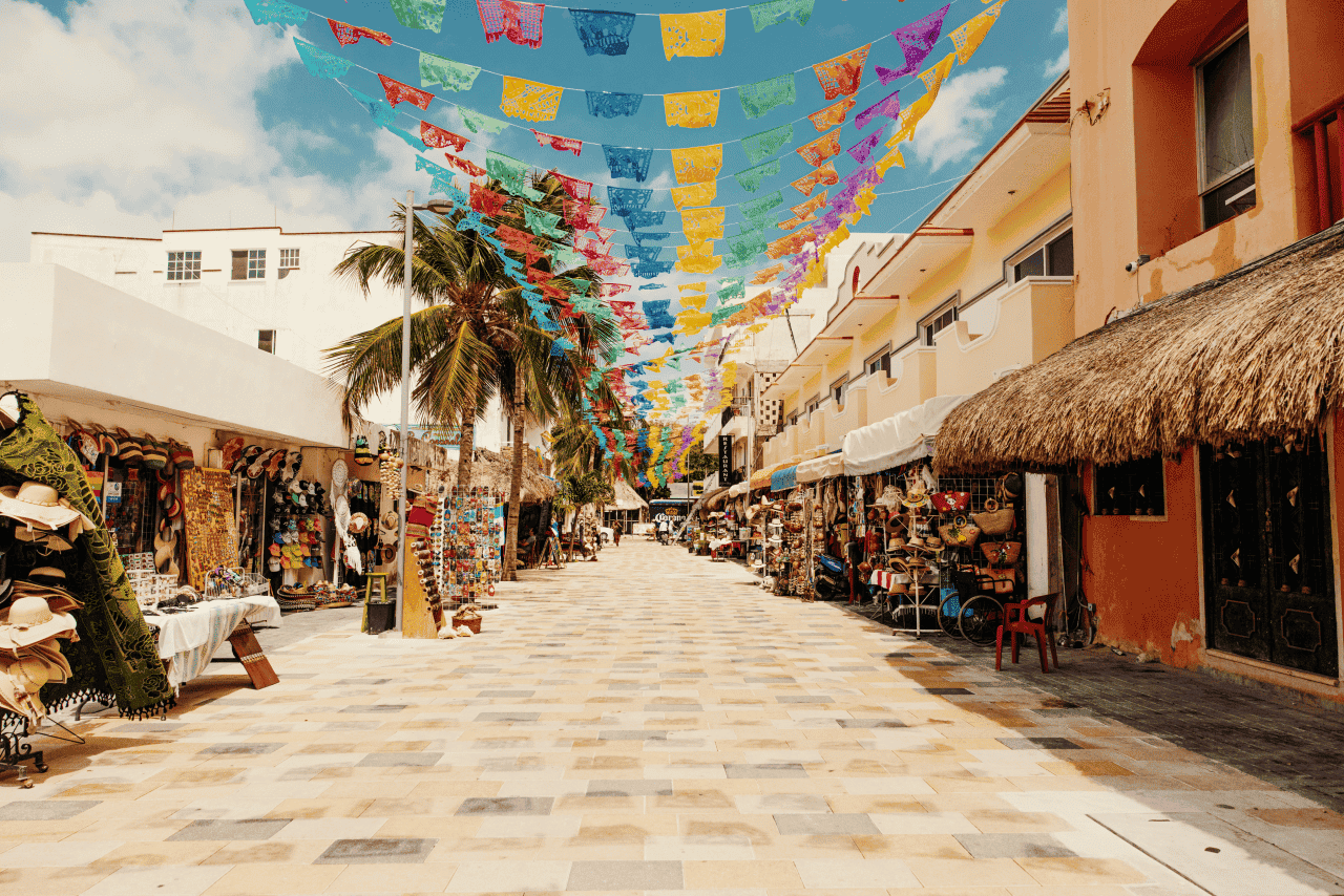 Handicraft shops lining the shopping street in Playa del Carmen called Quinta Avenida, with colorful Mexican flags above