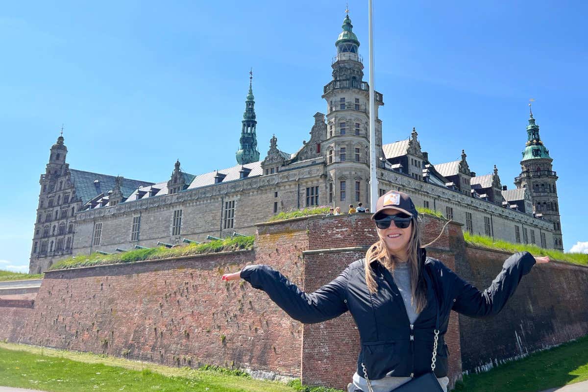 Romina Biggo con los brazos abiertos junto al castillo de Kronborg, cerca de la población danesa de Elsinor