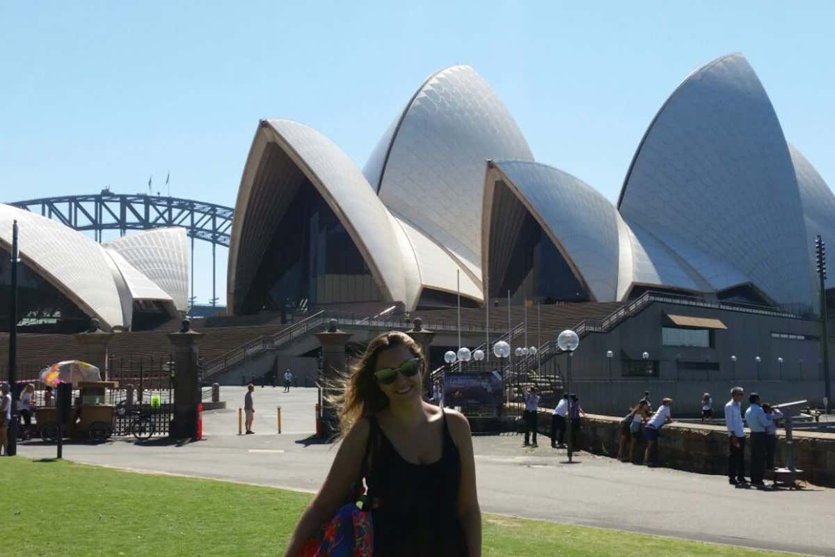 Romina Biggo posando con ropa de verano frente a la Ópera de Sídney en un día despejado