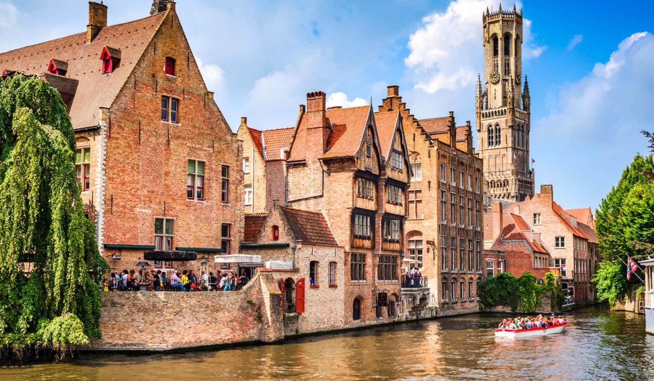 Canali a Bruges accanto a vecchi edifici in pietra in una giornata luminosa