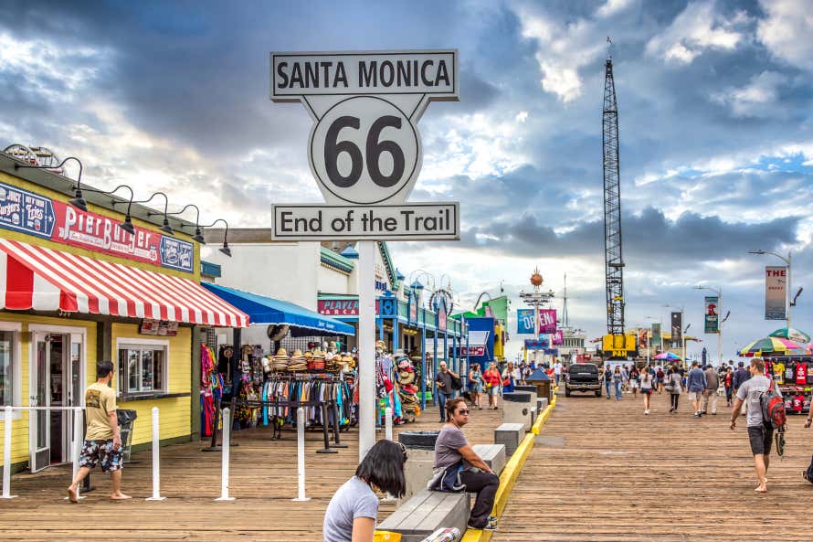 Cartel de fin de la Ruta 66 en el muelle de Santa Monica y personas paseando