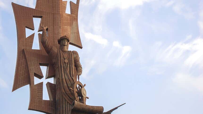 Estátua de cor marrom que mostra um navegante em uma caravela chamada de Nascimento do Novo Mundo, em Porto Rico