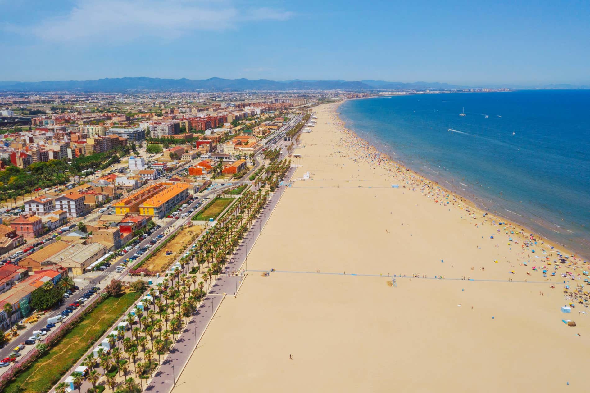 Aerial view over the long sandy Malvarrosa Beach, blue sea and nearby colourful houses in the Region of Valencia