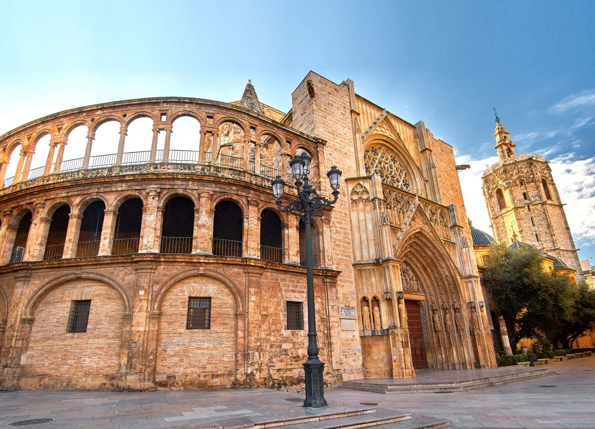 A section of the stone Cathedral of Valencia under a bright blue sky