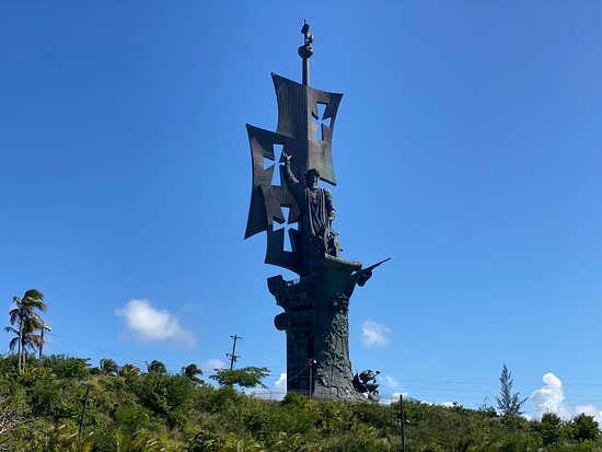 Statue de Birth of the New World sous un ciel bleu et entourée de végétation, une des plus grandes statues au monde