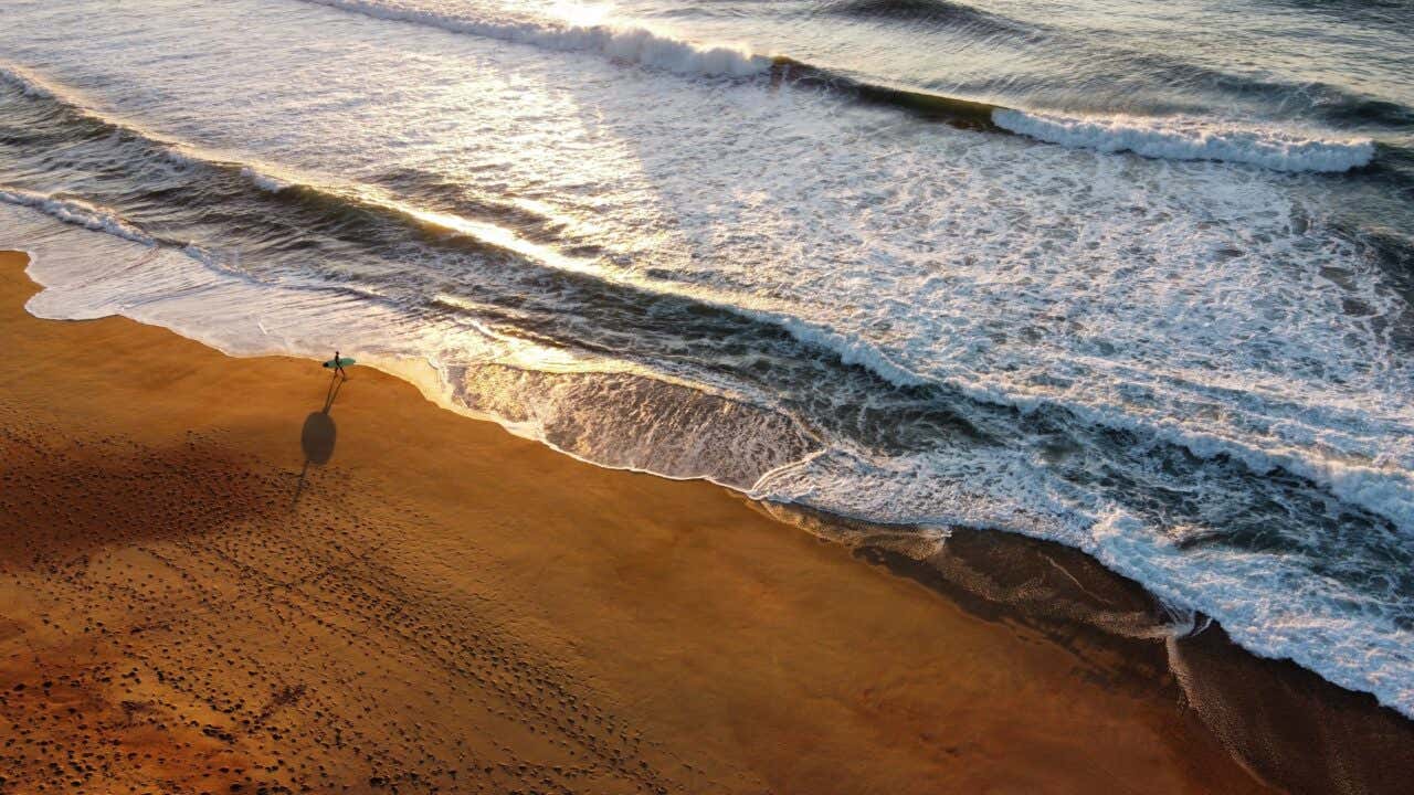 Vue aérienne sur une plage avec un surfeur