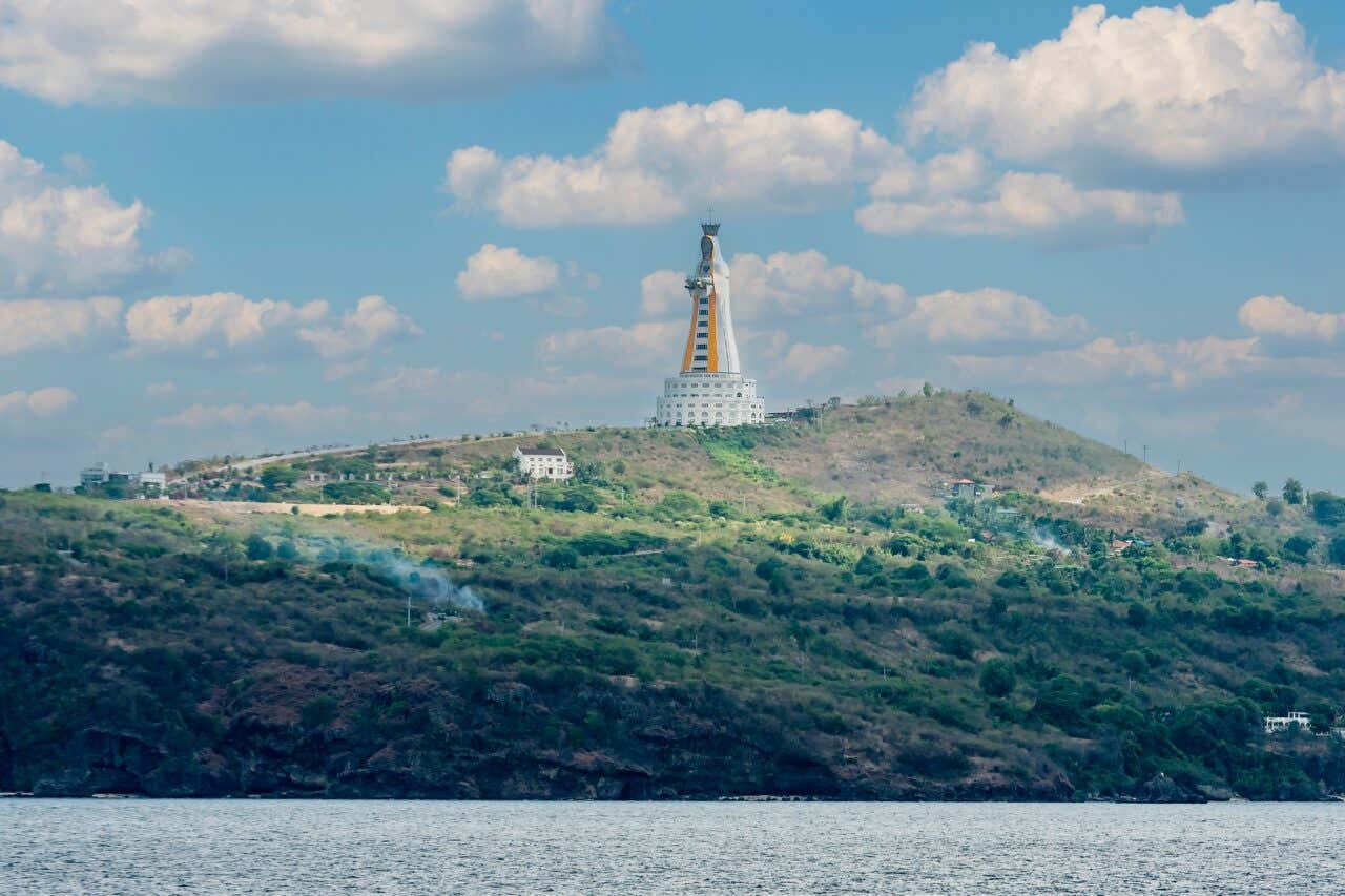 Vue panoramique sur la côte avec la statue de la Mère de Toutes les Asies en fond représentant une femme, une des plus grandes statues au monde