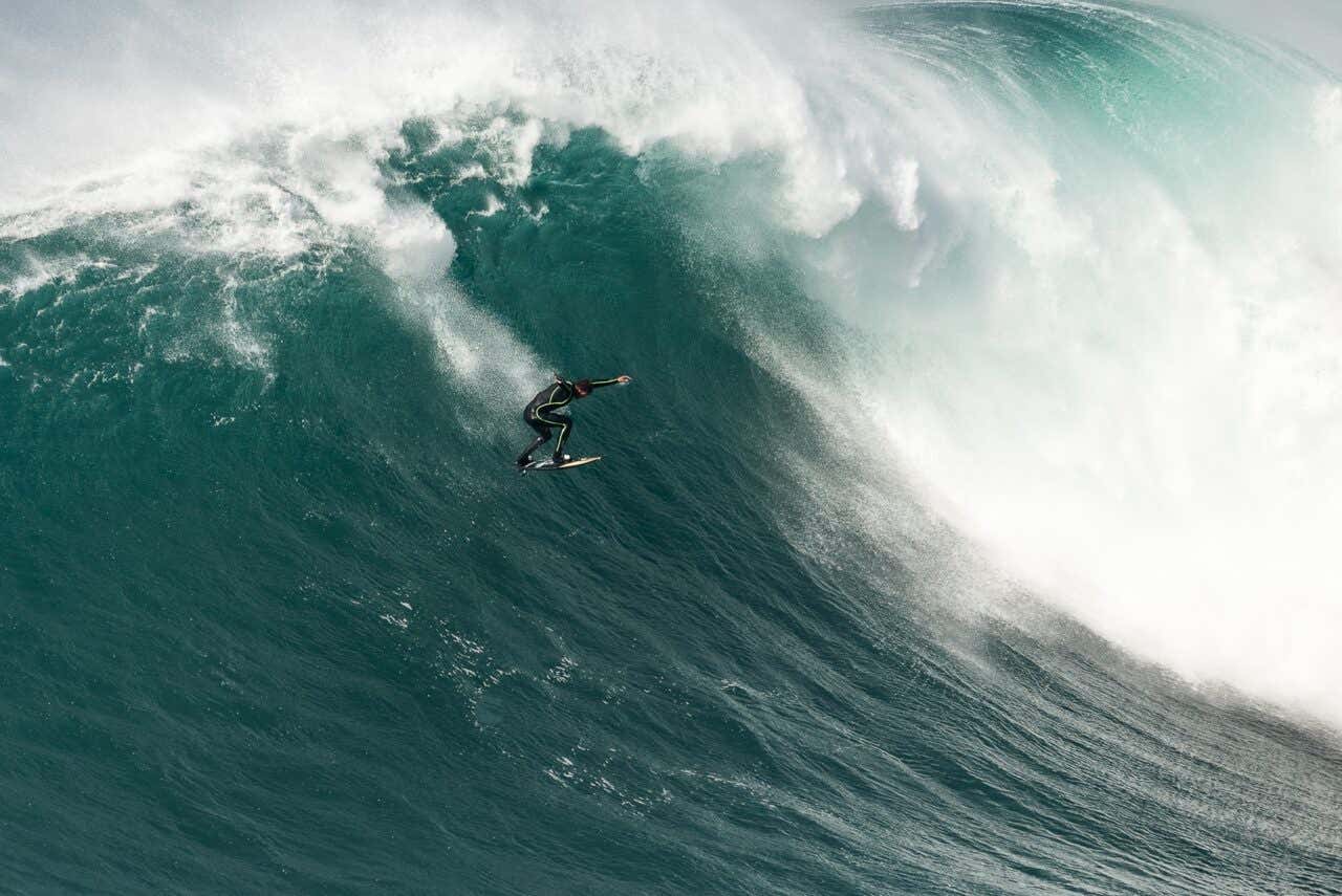 Surfeur sur une immense vague à Nazaré