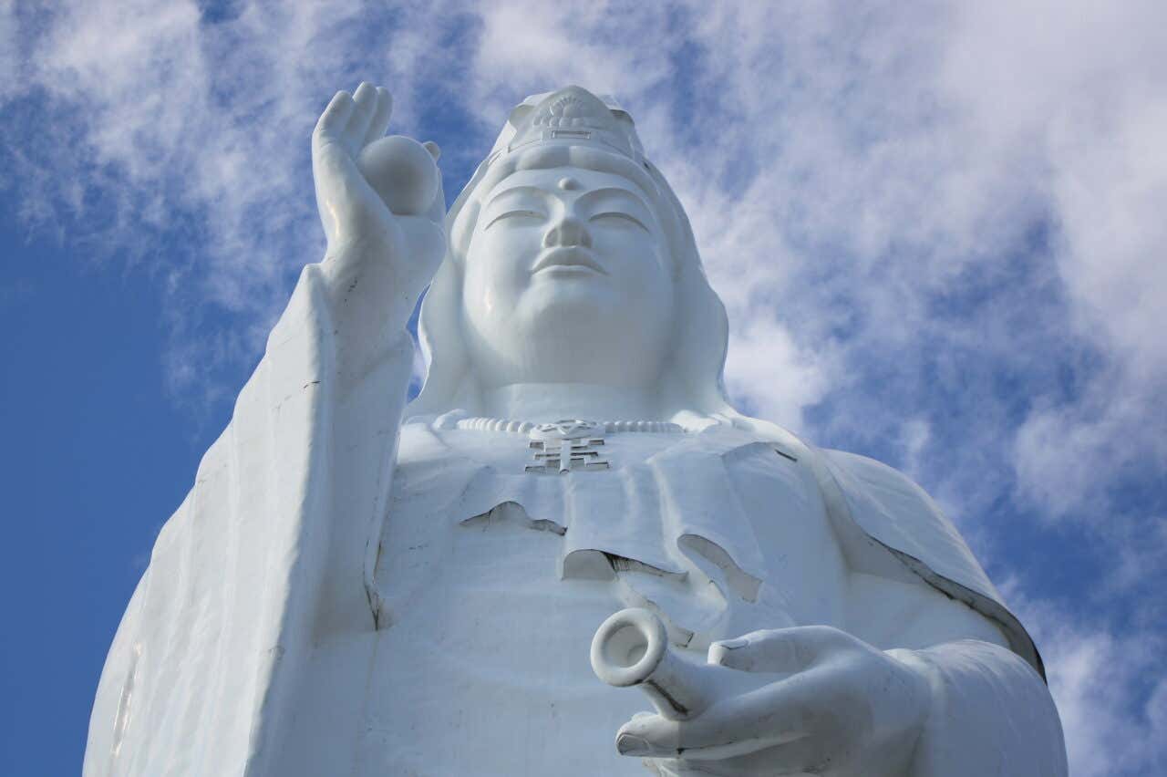 Vue en gros plan sur la partie supérieure d'une statue blanche représentant une femme, une des plus grandes statues au monde