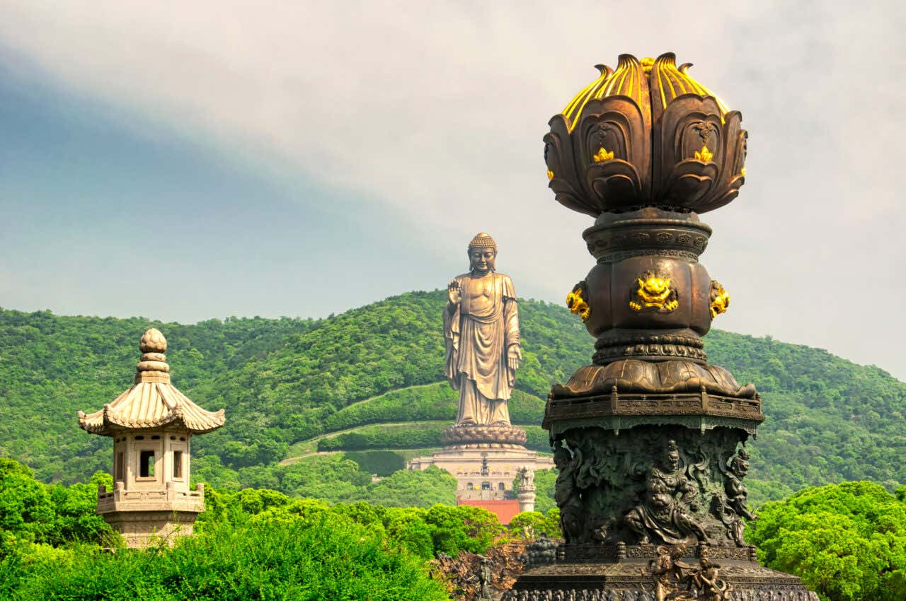 Une grande statue au milieu d'une végétation dense, une des plus grandes statues au monde