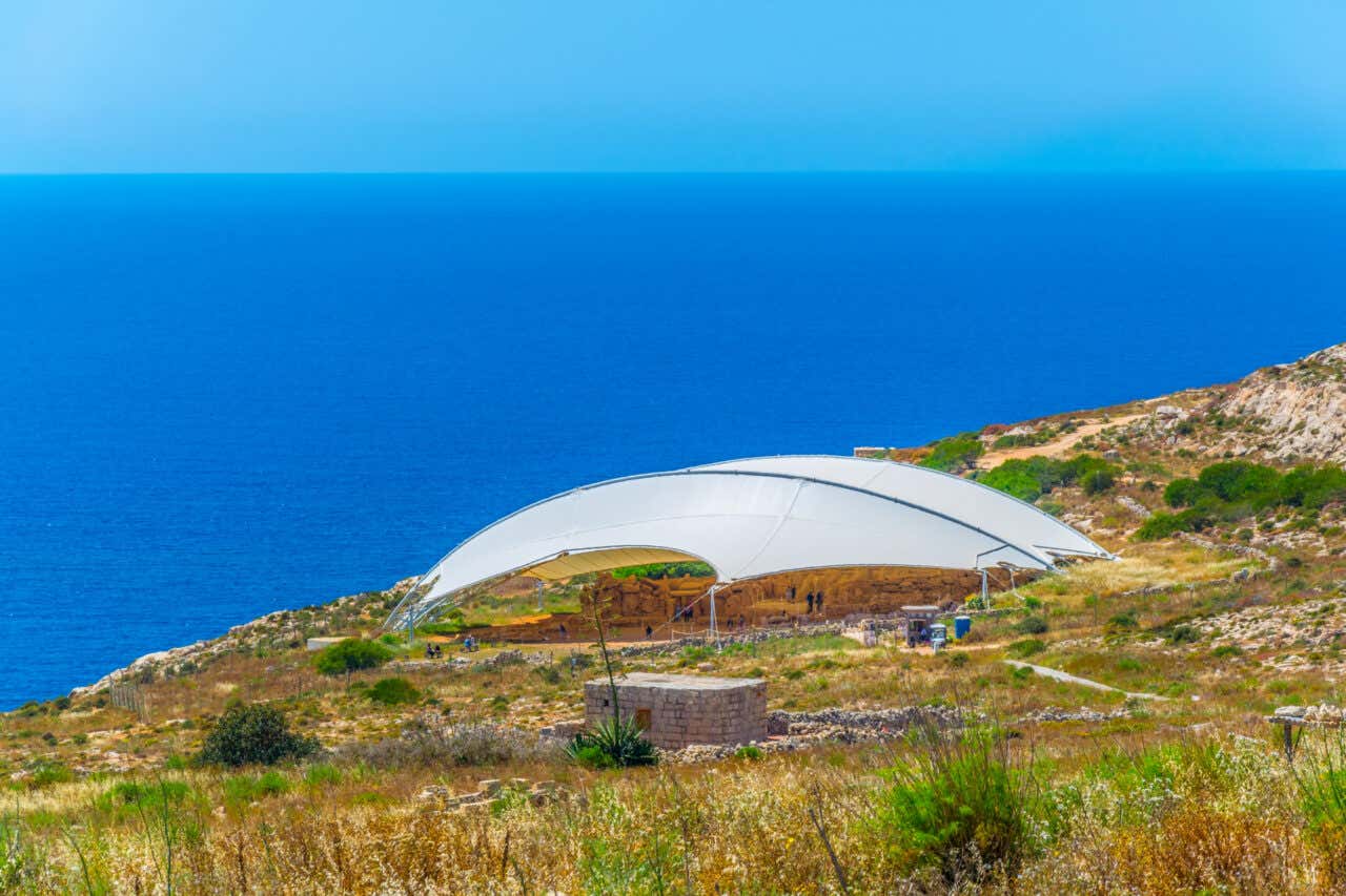 Temple mégalithique de Ħaġar Qim couvert avec la mer en fond