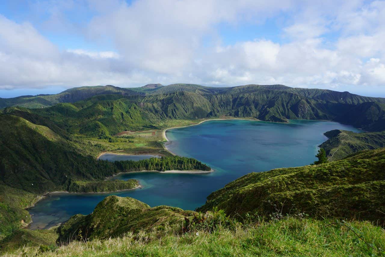 Uma extensa lagoa situada na cratera de um vulcão inativo rodeado de vegetação