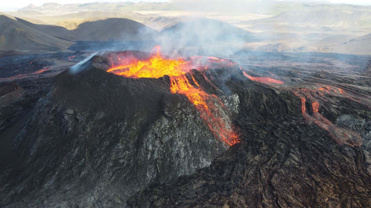 Erupção do vulcão Mauna Loa, com a caldeira repleta de magma e escoadas descendo por suas ladeiras