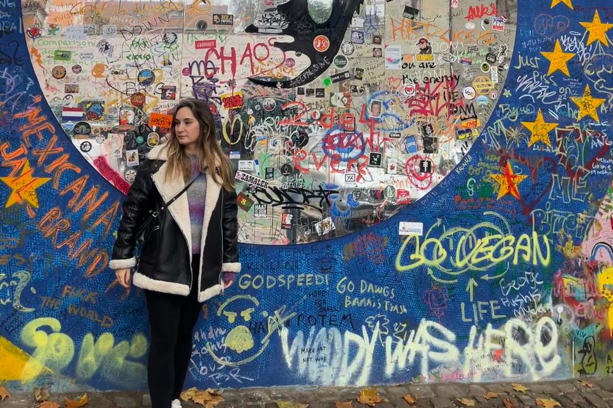 Una mujer frente al Muro de John Lennon de Praga