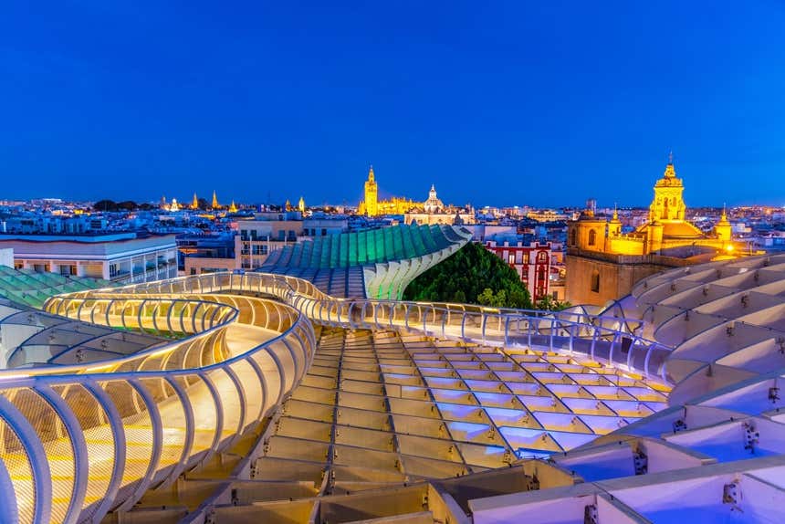 Vista nocturna de Sevilla con varias torres de iglesias iluminadas