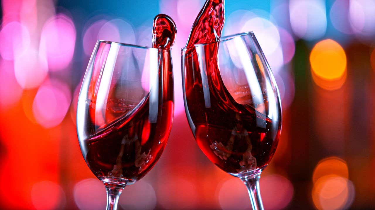 Deux verres à pied, le vin sortant après s'être choqués