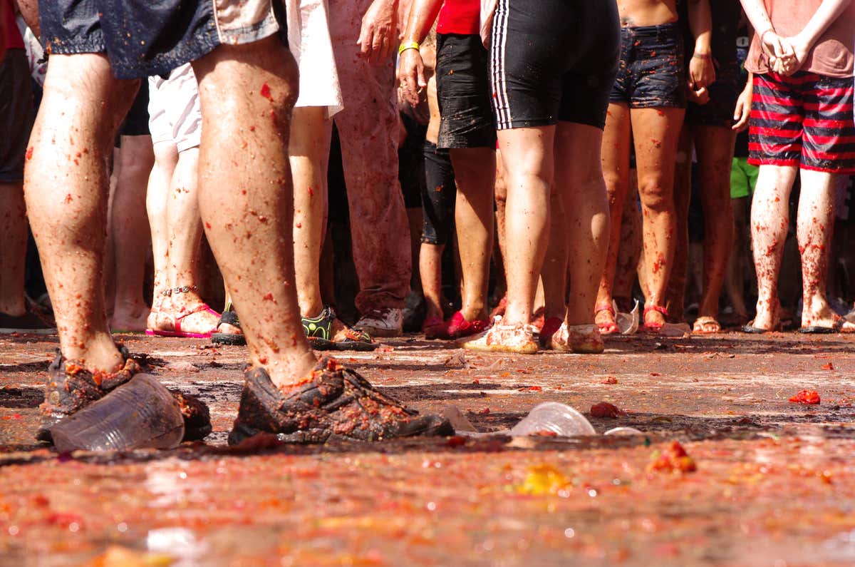 Varios turistas manchados de tomate en la famosa fiesta de la Tomatina de Buñol, fiesta tradicional de la Comunidad Valenciana
