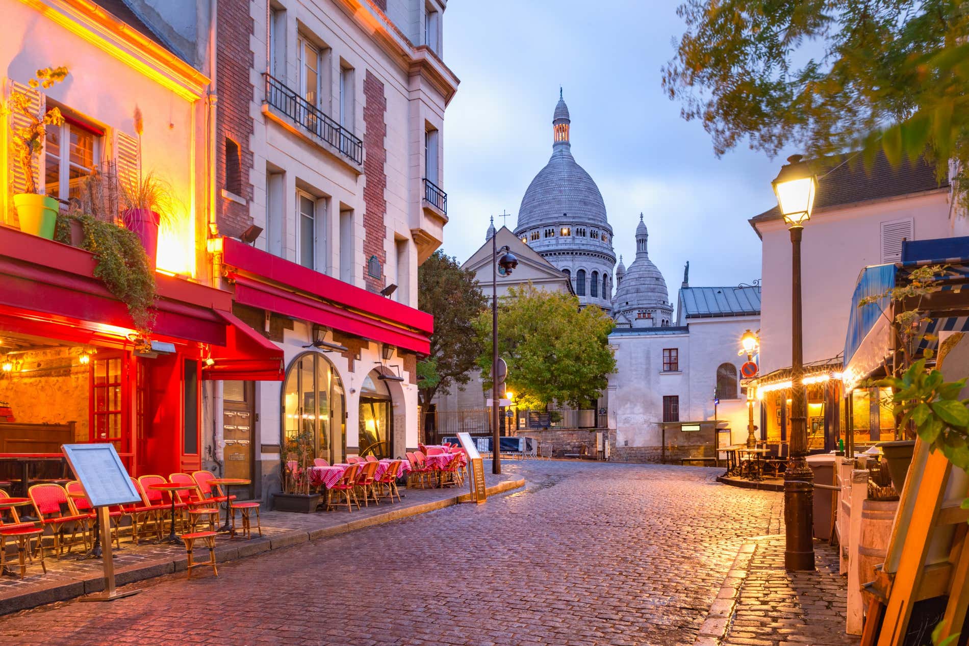 An image of Montmartre with street lights illuminating the street