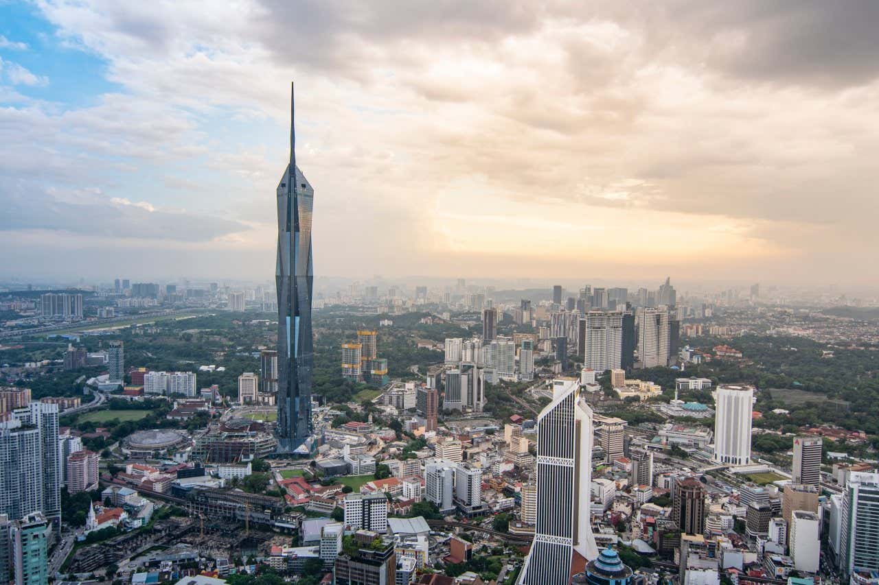 Aerial view of Kuala Lumpur, with Merdeka 118 on the left hand side of the image and a cloudy evening sky in the background
