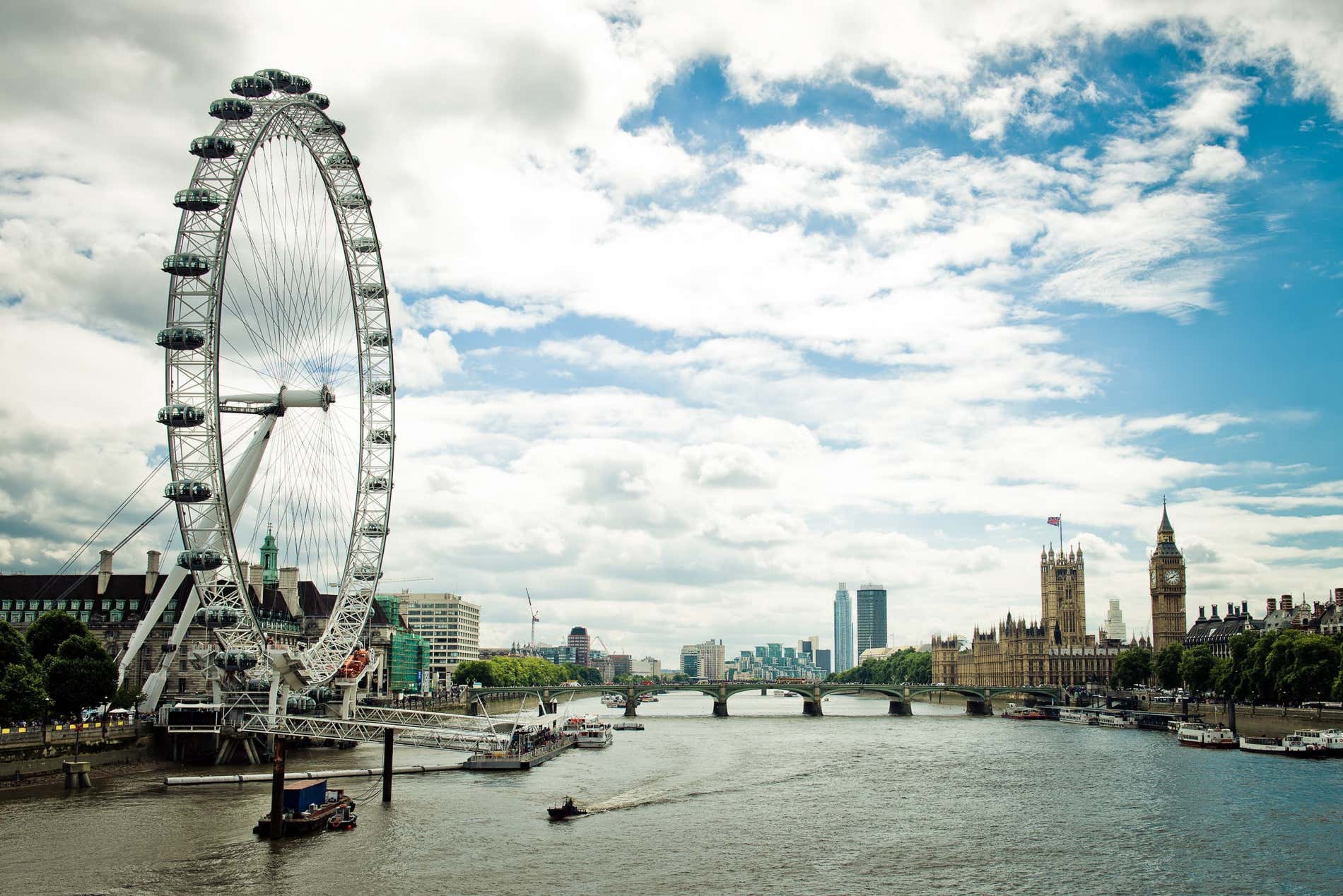 Vista panoramica del fiume Tamigi con il London Eye in evidenza e altri edifici sullo sfondo, come il Palazzo di Westminster