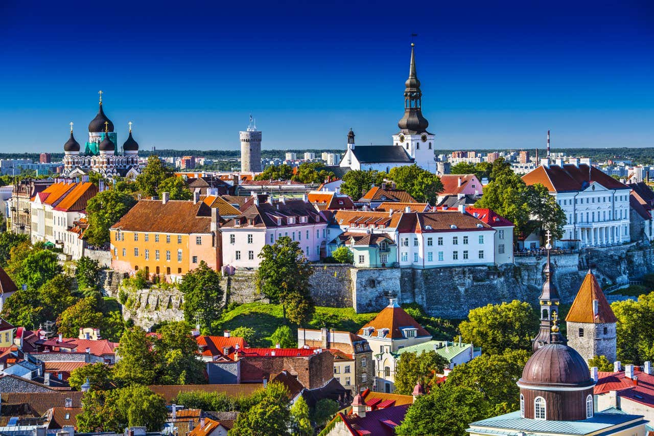 Vista do centro histórico de Tallinn, com torres medievais erguendo-se entre os telhados das casas coloridas