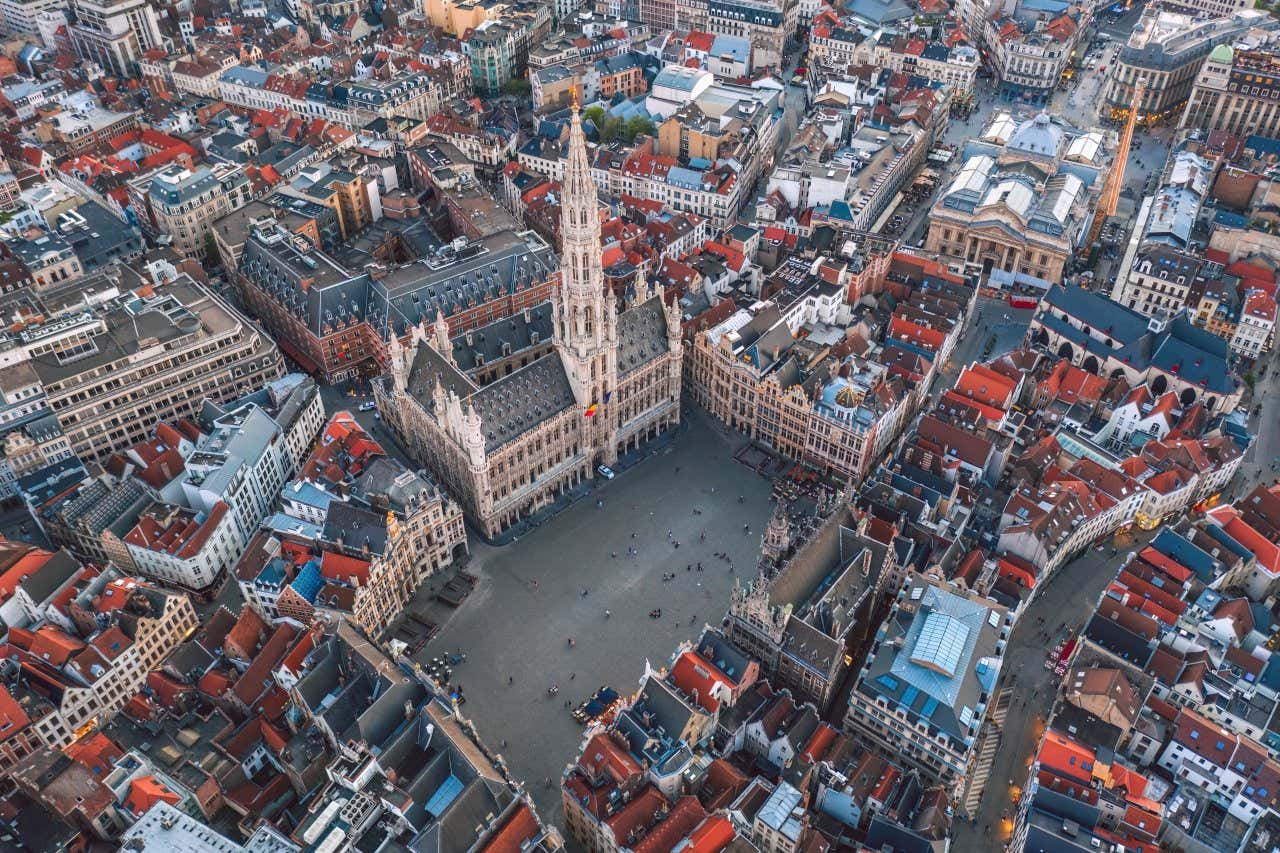 Foto aérea da Grand Place, a praça principal de Bruxelas, com a prefeitura e uma alta torre gótica