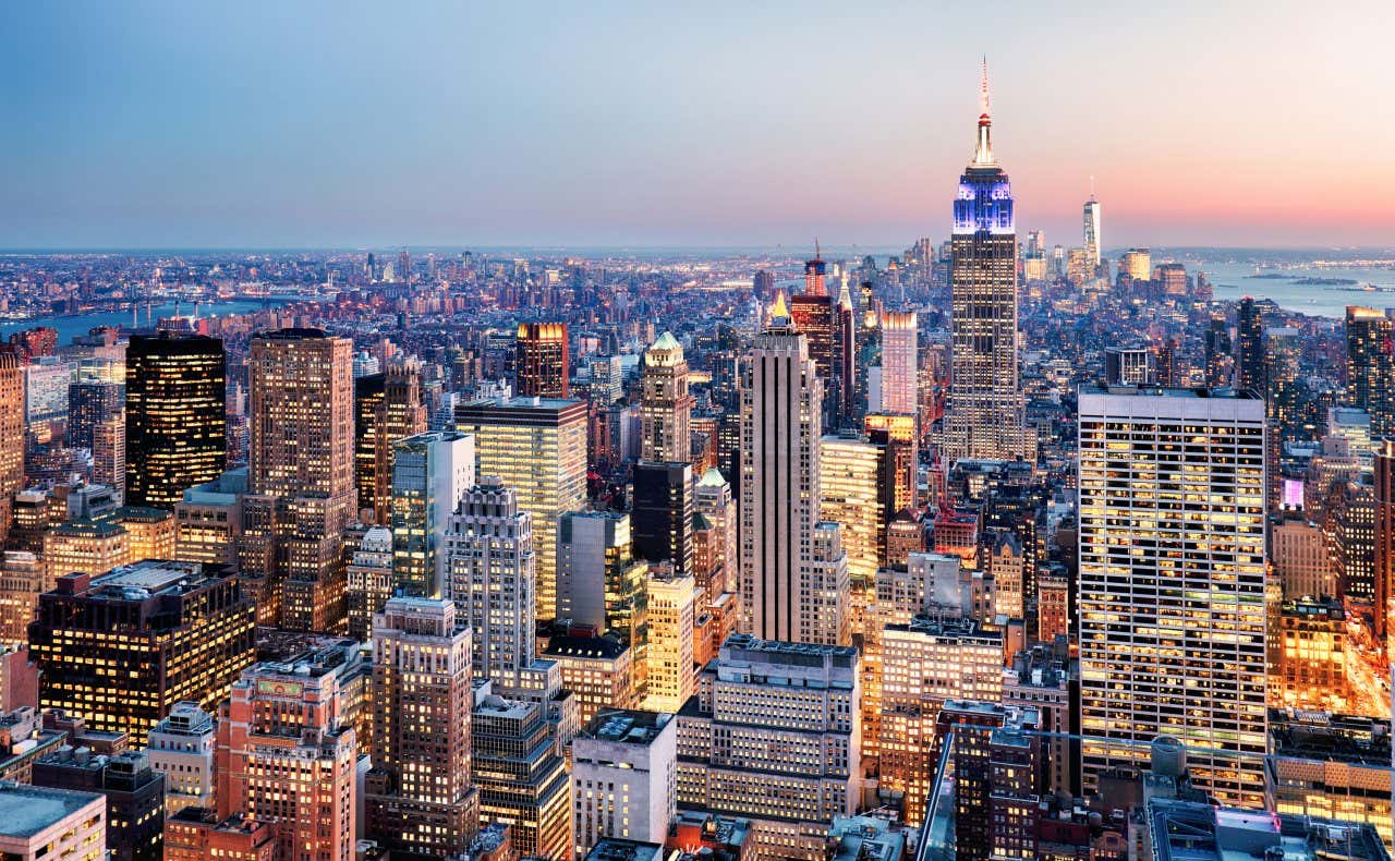 An aerial view of the illuminated buildings of New York at sunset, perhaps the most beautiful city in the world.