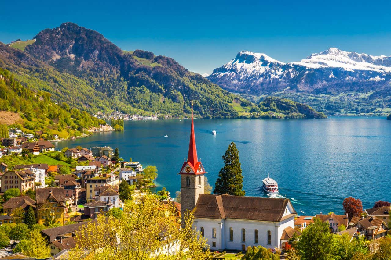 View of Lucerne, with the church in the foreground, the lake in the background and the snow-capped mountains in the distance