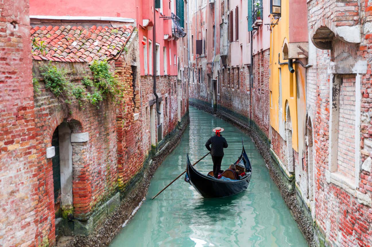 un gondoliere naviga un canale circondato da antichi palazzi di Venezia, una delle più belle città del mondo