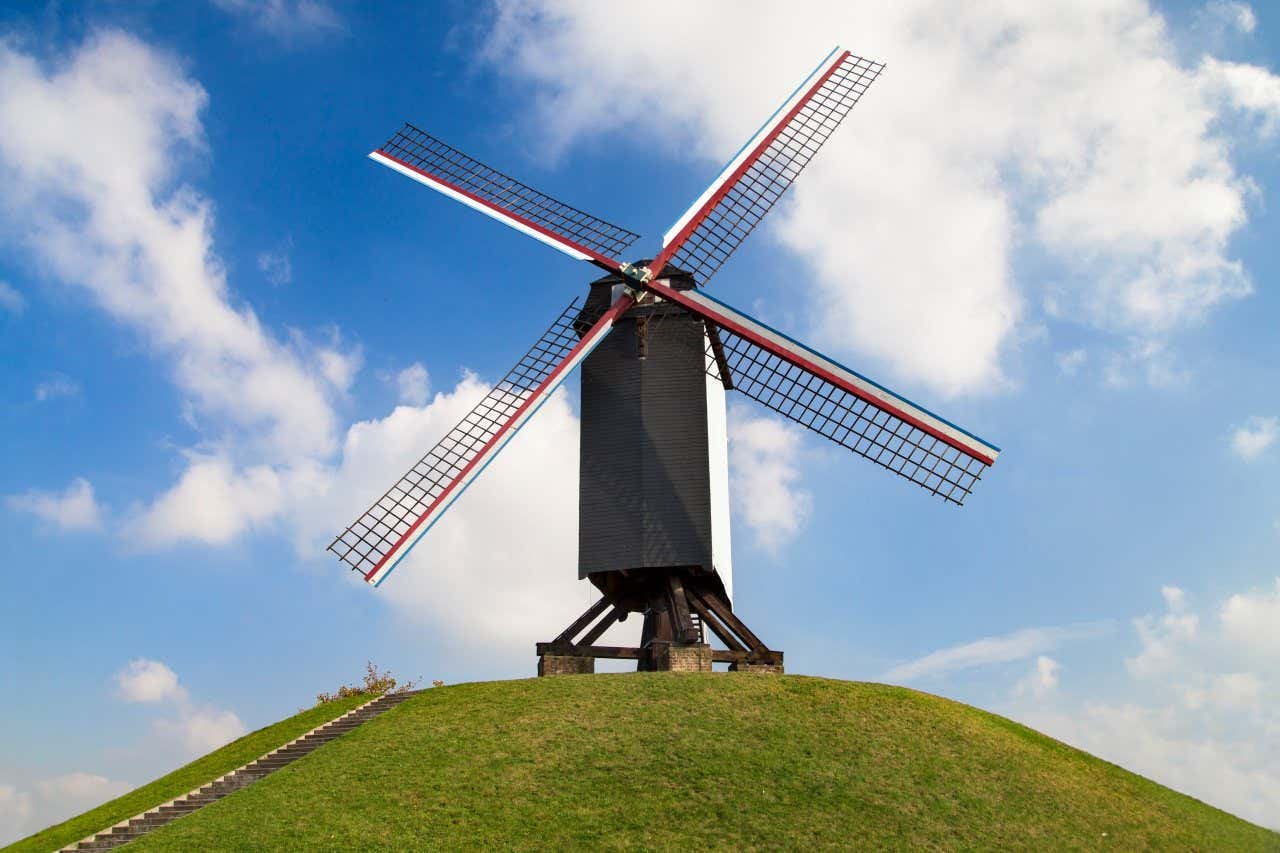 Um moinho de vento preto com o céu limpo ao fundo