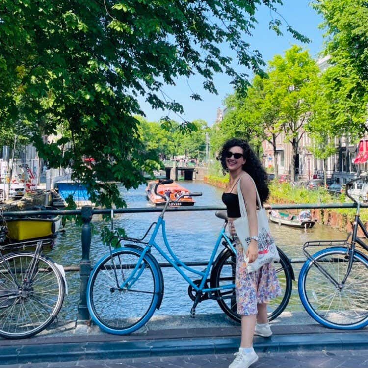 Oumayma El Hamri, en un puente de Ámsterdam con bicicletas y un río al fondo.