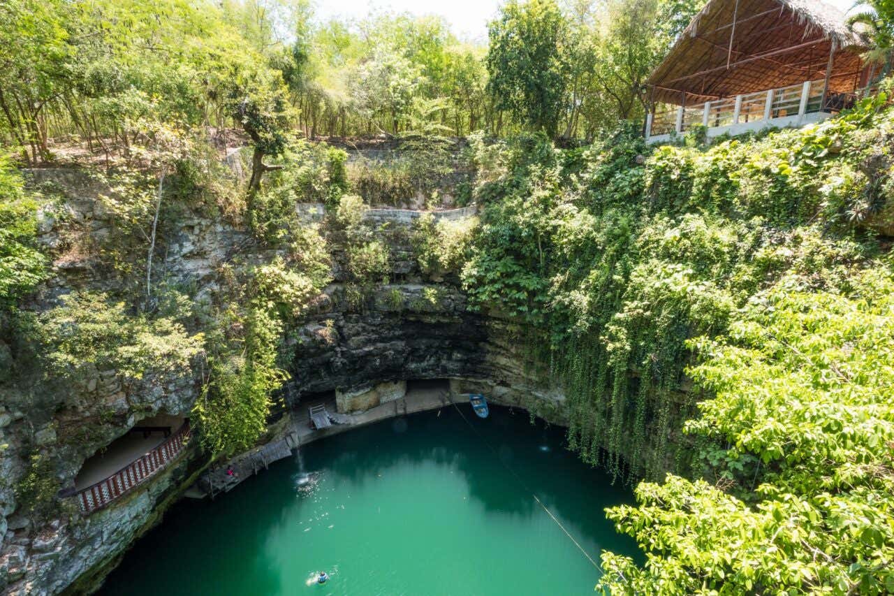 Lago verde rodeado por paredes de pedra e vegetação