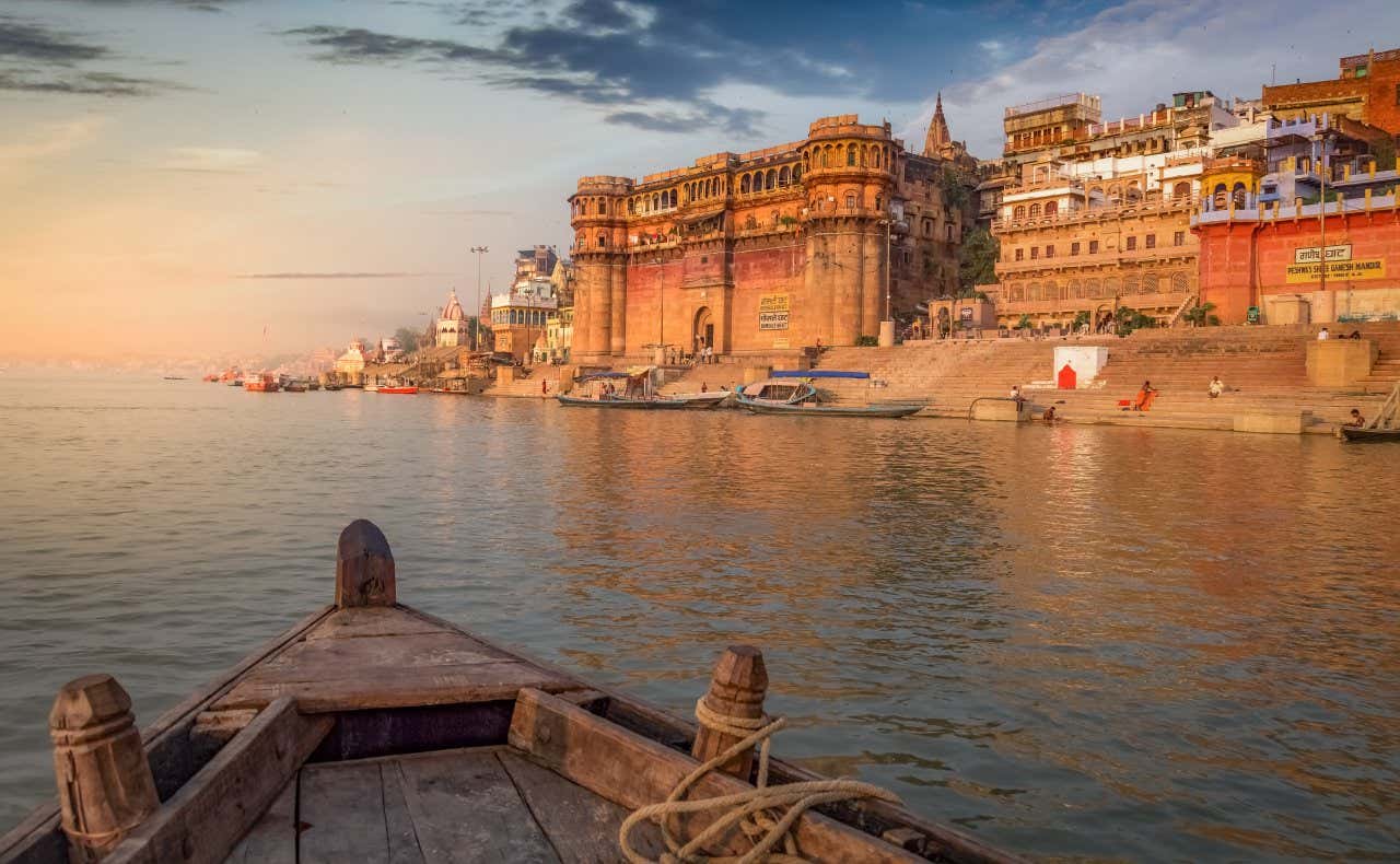 A shot of Varanasi as seen from a boat in the water as the sun sets