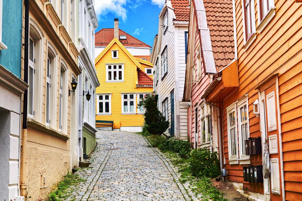 Une rue pavée de Bergen bordée de maisons en bois aux couleurs pastel par temps clair