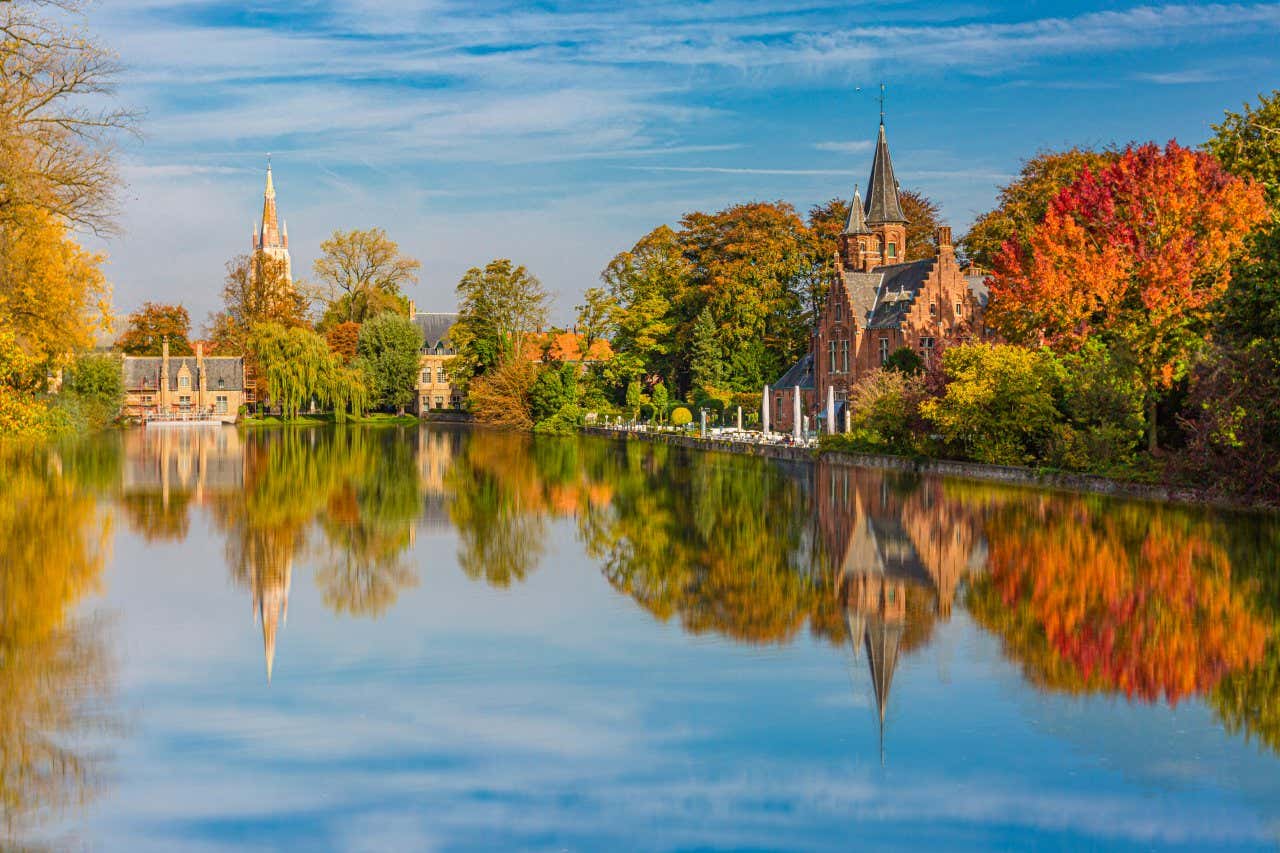Reflejo de las siluetas del parque Minnewater en el lago del Amor, en la ciudad de Brujas, un día soleado