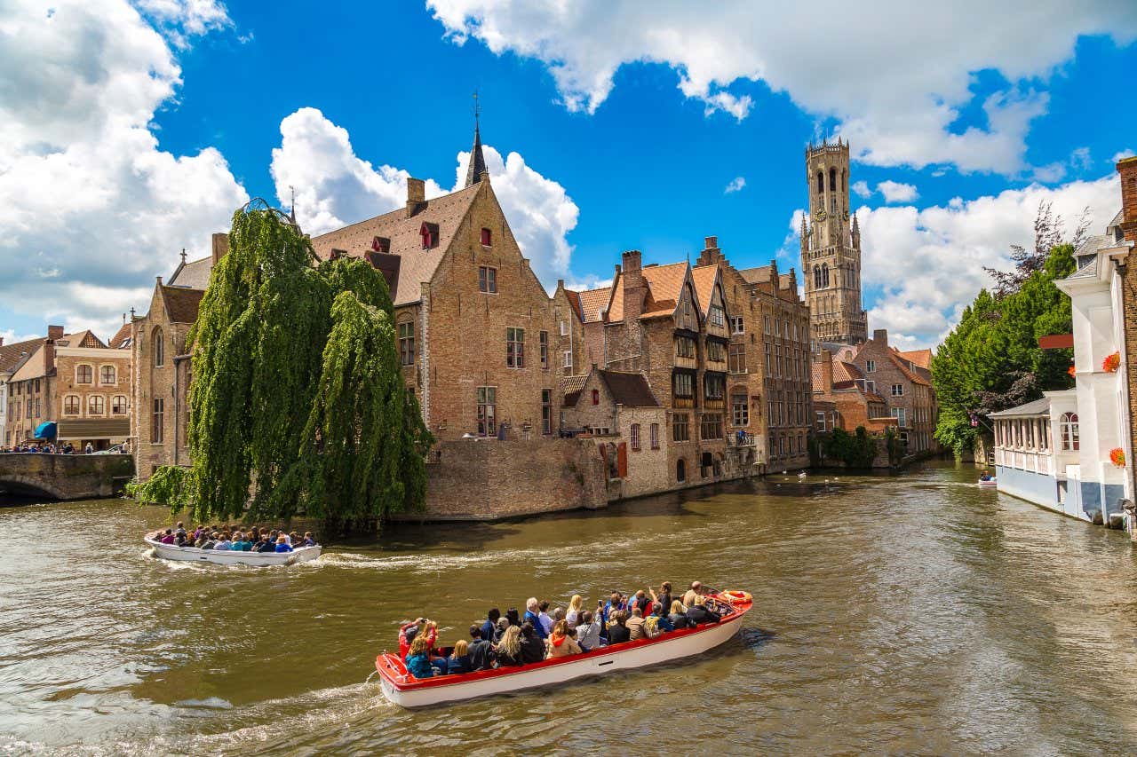 Dos grupos de personas a bordo de dos lanchas navegando por los canales de Brujas en un día soleado de verano