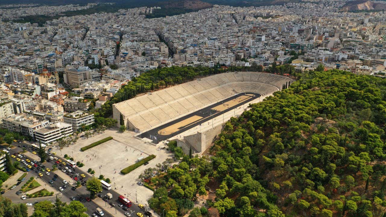 An aerial shot of the Panathenaic Stadium, with a view of the rest of the city in the background.