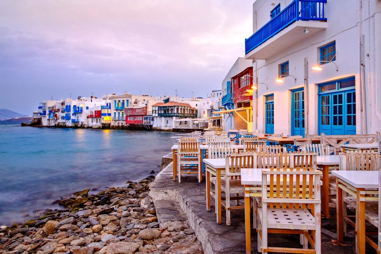 A seaside restaurant with outdoor seating and colourful balconies.